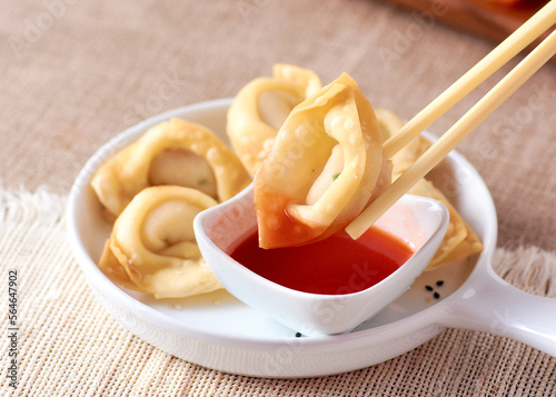 Dim sum with chopsticks and red sauce