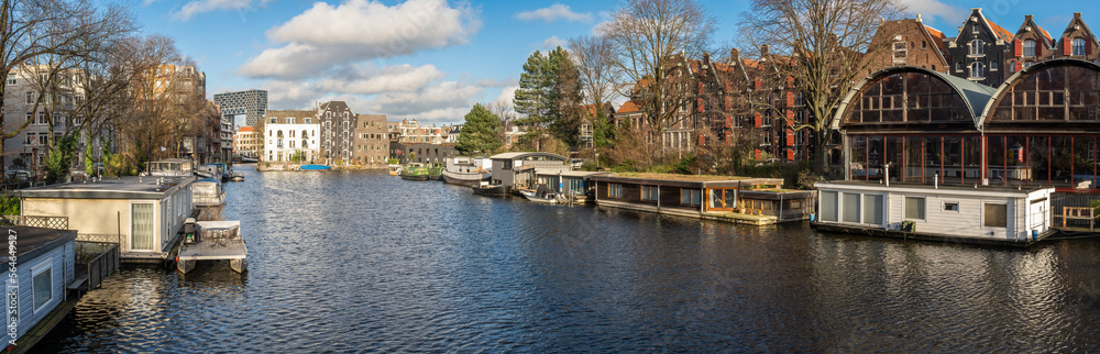 Panorama of Western Islands neighbourhood in centrum district of Amsterdam, view of houseboats and houses along Prinseneilandsgracht canal