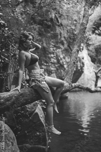 Chica guapa morena espa  ola en bikini en un rio de un bosque verde frondoso y natural