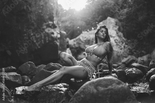 Chica guapa morena espa  ola en bikini en un rio de un bosque verde frondoso y natural