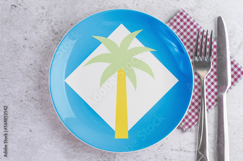 A Plate with the Flag of Clipperton Island, Cutlery and Napkins on the Mable Table. photo