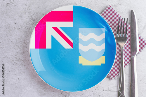 A Plate with the Flag of Falkland Islands(Malvinas), Cutlery and Napkins on the Mable Table. photo