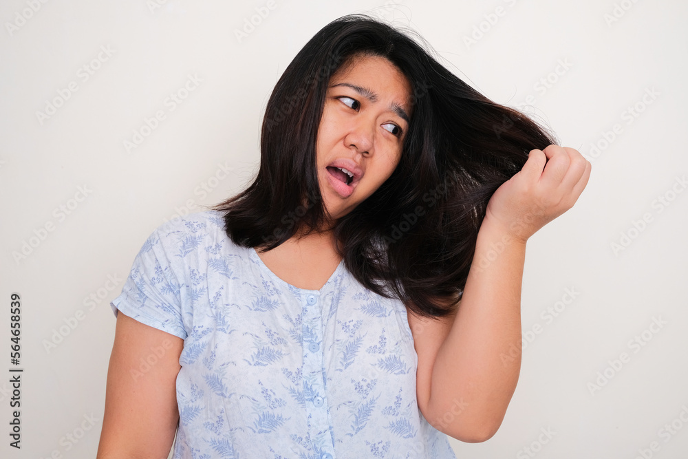 Asian young women looking to her hair with worried expression