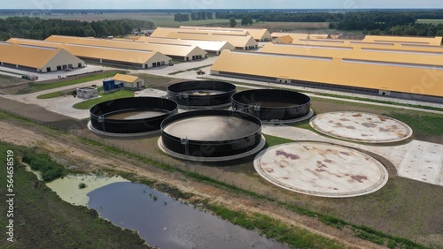 Large round metal tanks for storing liquid waste from an agricultural farm. Open-top open-air tanks for cow manure processing at an agricultural farm. Evaporation of manure.