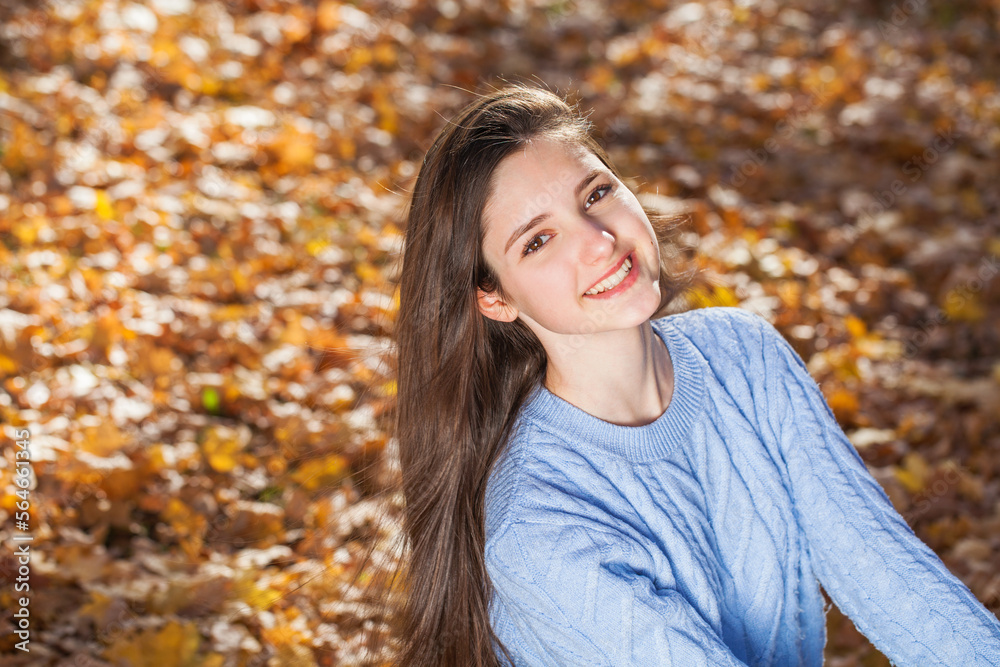Portrait of a young girl in blue sweater, autumn park outdoor Portrait of a young girl in blue sweater, autumn park outdoor
