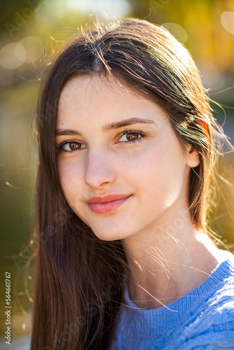 Portrait of a young girl in blue sweater, autumn park outdoor