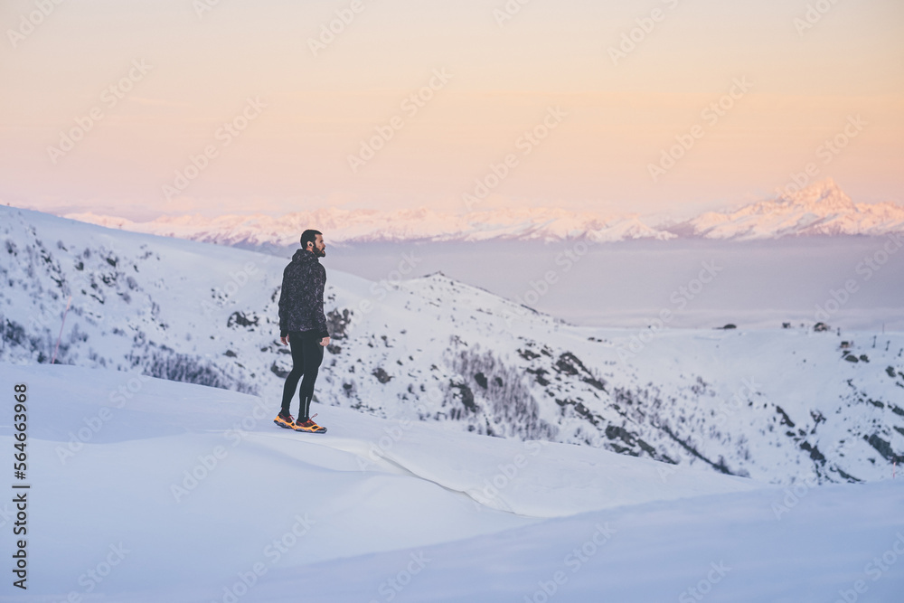 Man running on the snow at the top of a mountain