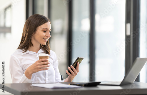 Free Download Smiling beautiful Asian businesswoman analyzing chart and graph showing changes on the market and holding smartphone at office. - GFXLoad
