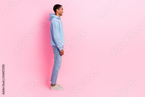 Profile side photo of nice glad man wear blue clothes stand near empty space promote autumn collection isolated on pink color background