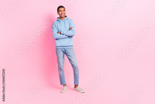 Photo of positive youngster man wear blue trendy clothes arm crossed look empty space interesting news isolated on pink color background