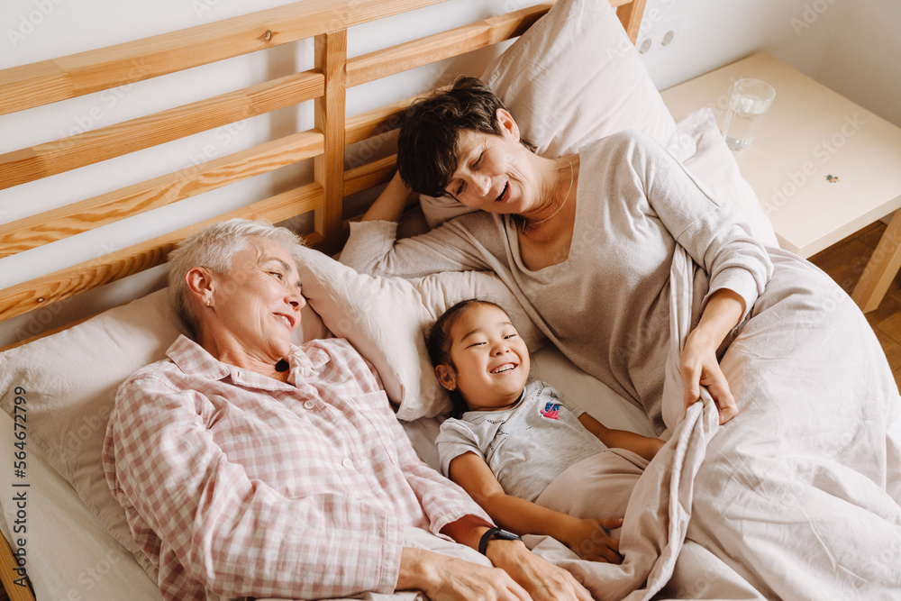 Obraz premium Happy mature same sex couple with adopted asian little girl