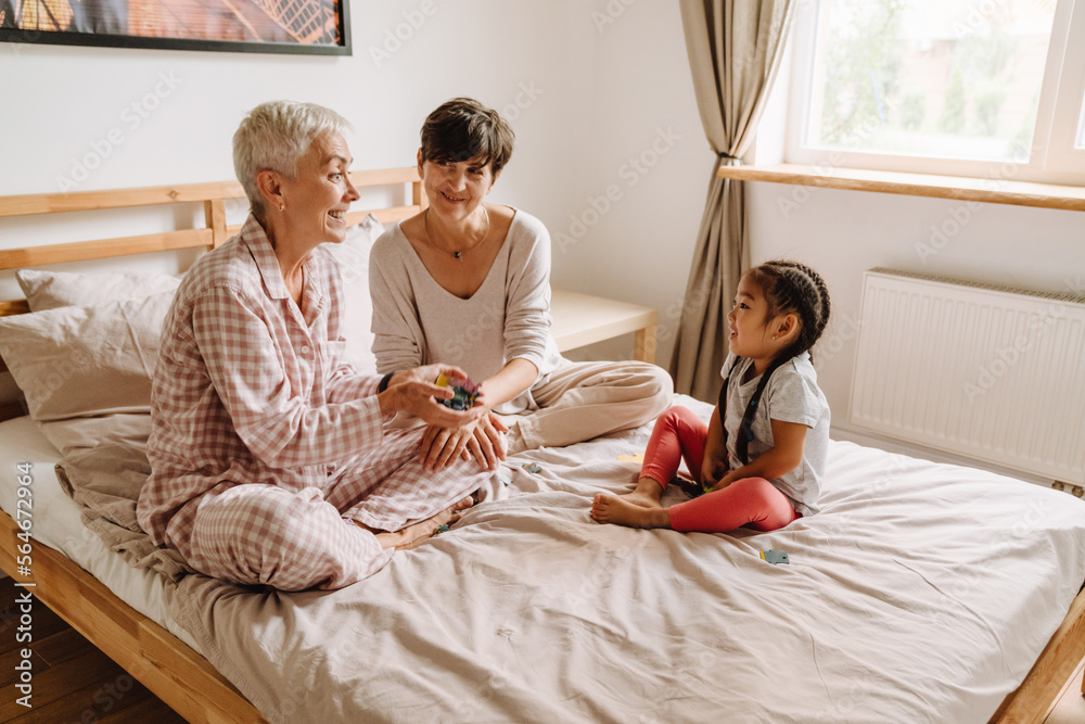 Happy smiling same sex couple with adopted asian little girl  