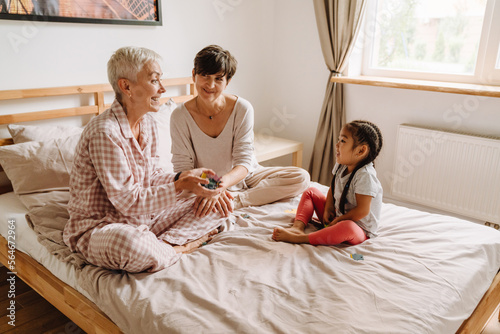 Happy smiling same sex couple with adopted asian little girl photo