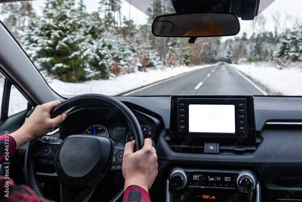 man driving a car on an winter road. back view. Close-up of hands on a steering wheel. view from the driver's back.