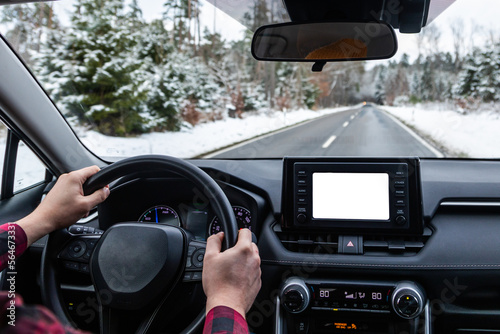 man driving a car on an winter road. back view. Close-up of hands on a steering wheel. view from the driver's back. © drotik