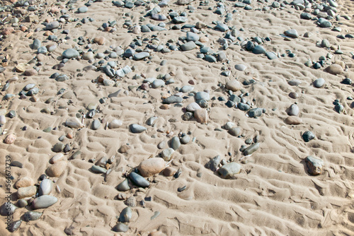 Pebble stones in wet sand on the beach. 