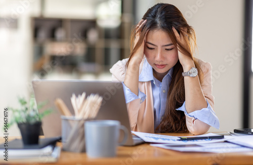 Young business Asian women are stressed while working on laptop, Tired asian businesswoman with headache at office, feeling sick at work copy space in workplace an home office.