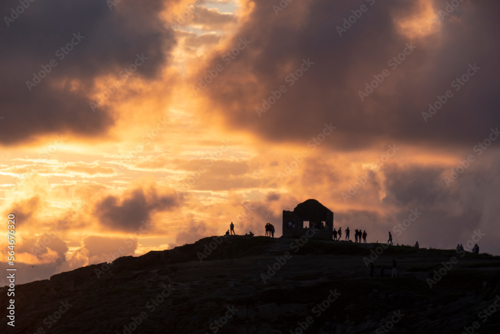 Silouette of a ruined house and some people over a hill at sunset Silouette of a ruined house and some people over a hill at sunset