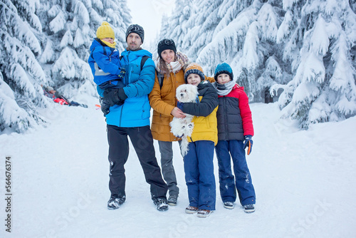 Happy family witn children, hiking in mountains wintertime, lots of snow, beautiful winter forest