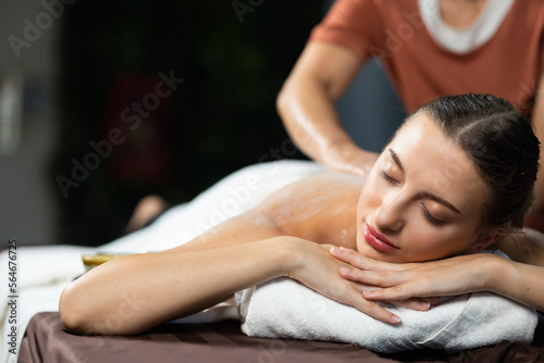 Back spa massage. Beautiful cuacasian female getting massage in beauty spa and wellness center. Facial treatment and skin care concept.