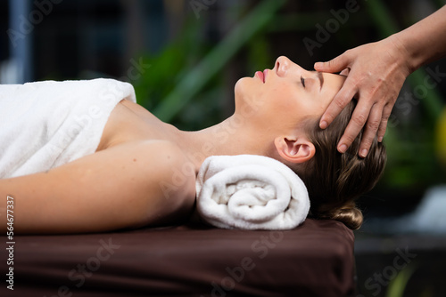 happy beautiful caucasian woman enjoying head massage at the spa and wellness center