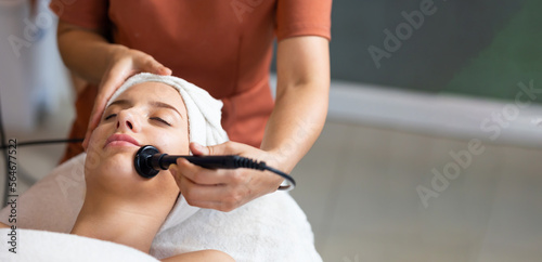 Tools facial mask treatment. Beautiful caucasian woman getting face massage in beauty spa and wellness center. Facial treatment and skin care concept.