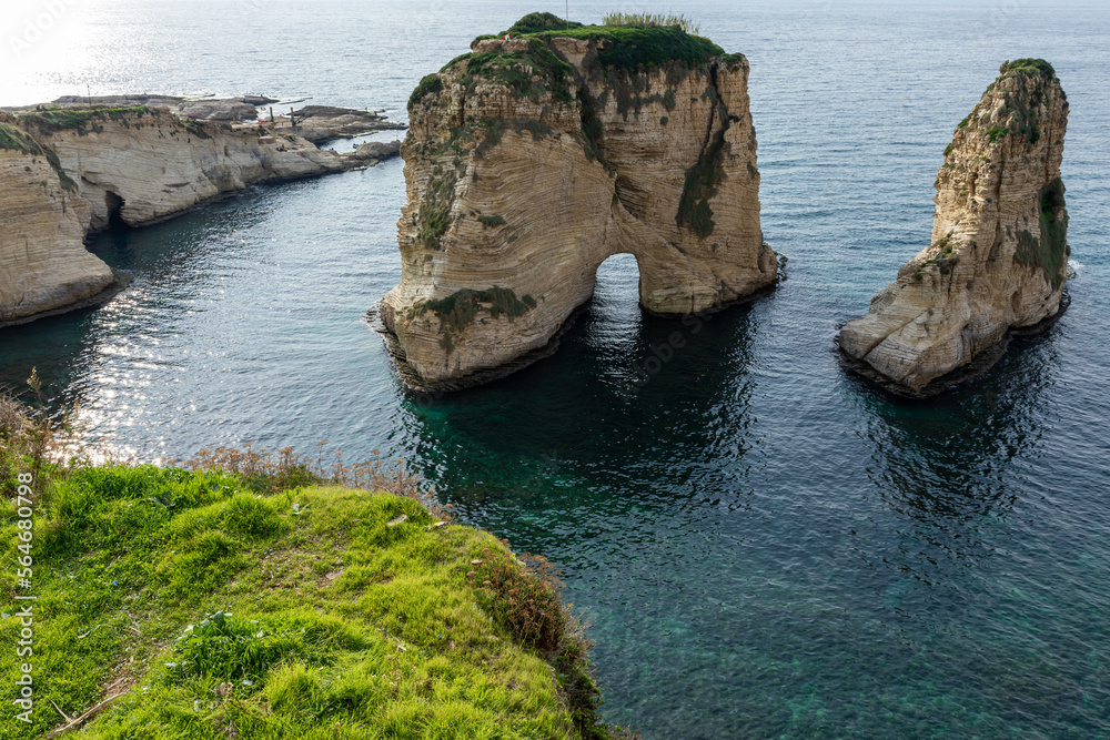 Naklejka premium Raouche Rocks in Beirut, Lebanon in the sea during daytime. Pigeon Rocks in Mediterranean Sea. Popular Tourist Destination in Beirut. 