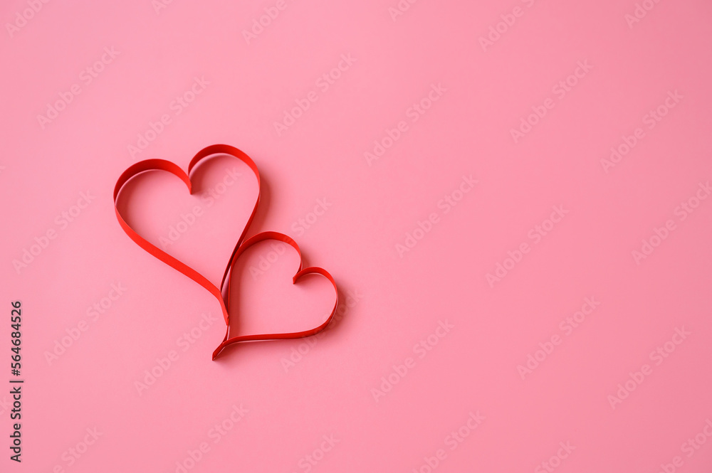 Two red paper hearts on a pink background. Background for Valentine. Valentine's Day. Love concept.