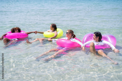 Teenage girl friendship enjoy laughing play on sea swimming with water inflation toy on blue sky day
