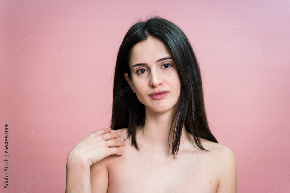 Charming woman looking at camera and and touching her neck Charming woman looking at camera and and touching her neck