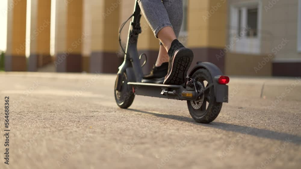 Girl rides an electric scooter. Child travel cheerfully. Empty city street. Legs on an electric scooter. Girl travel on scooter. Child on deserted street. Electric scooter close up. City travel girl Girl rides an electric scooter. Child travel cheerfully. Empty city street. Legs on an electric scooter. Girl travel on scooter. Child on deserted street. Electric scooter close up. City travel girl