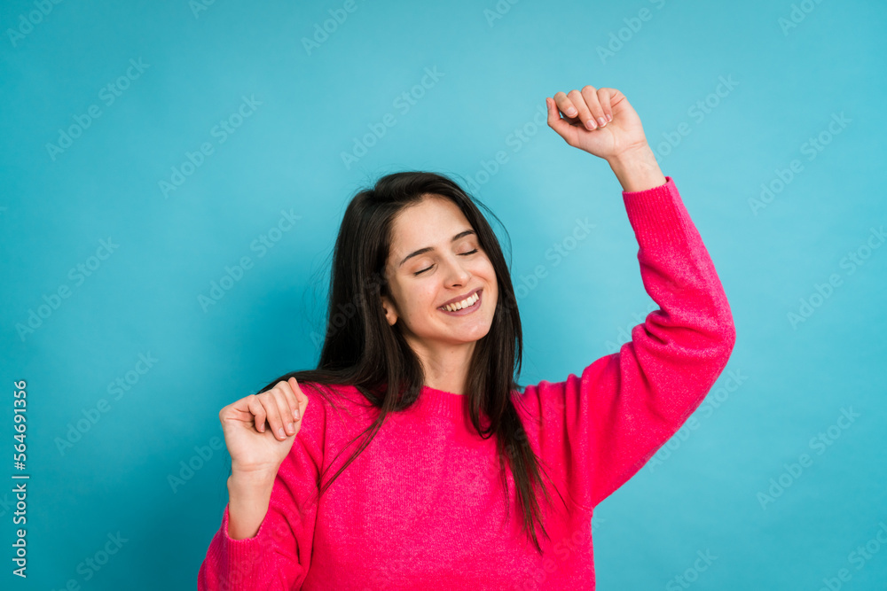 Fototapeta premium Smiling woman dancing and listening music