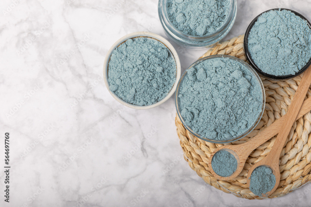 Blue spirulina powder in bowls and spoon on white marble background. Natural vegan superfood. food supplement. place for text. Copy space. Blue spirulina powder in bowls and spoon on white marble background. Natural vegan superfood. food supplement. place for text. Copy space.