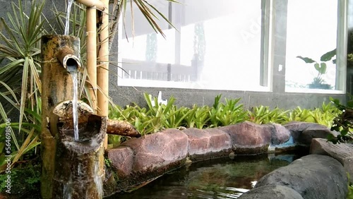 pond in the garden with a shower made of bamboo