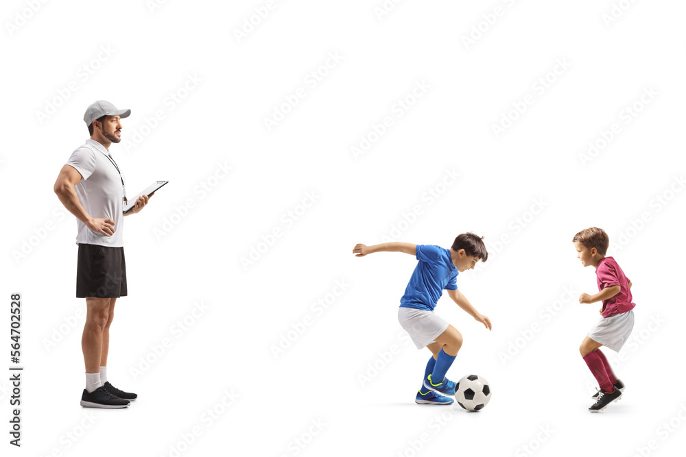 Coach watching two boys playing football Coach watching two boys playing football