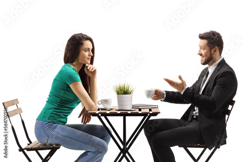 Young woman sitting at a wooden table and listening to a businessman