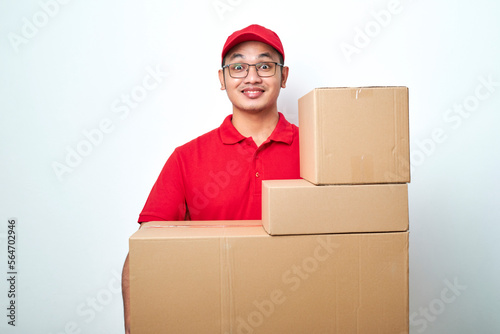 Pleasant smiling asian courier, delivery man in red uniform bring parcels to doorstep, carry boxes with orders