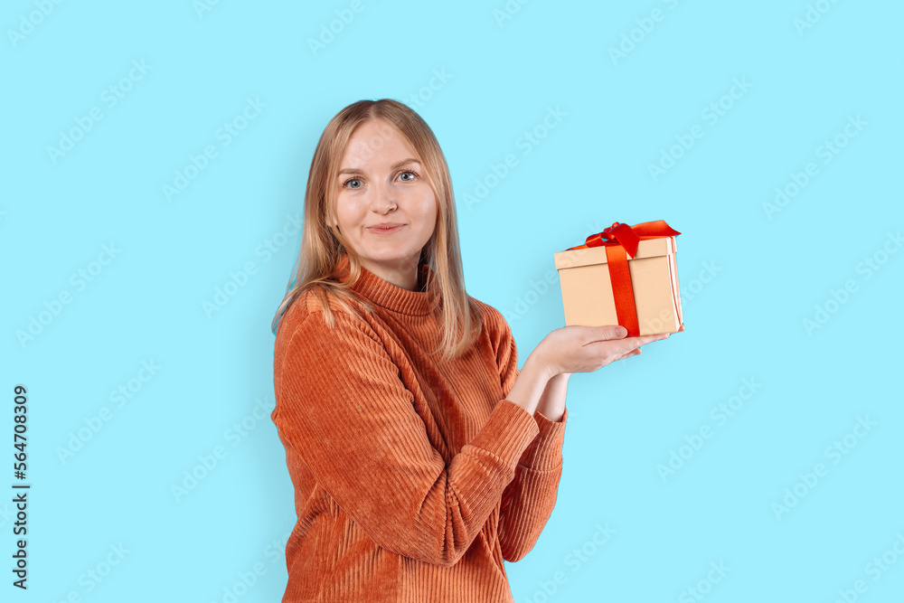 Happy young blonde woman 20s wears green denim jacket hold shake red present box with gift ribbon bow, close up, copy space. Anniversary, happy birthday, Valentine day and positive emotions. Happy young blonde woman 20s wears green denim jacket hold shake red present box with gift ribbon bow, close up, copy space. Anniversary, happy birthday, Valentine day and positive emotions.