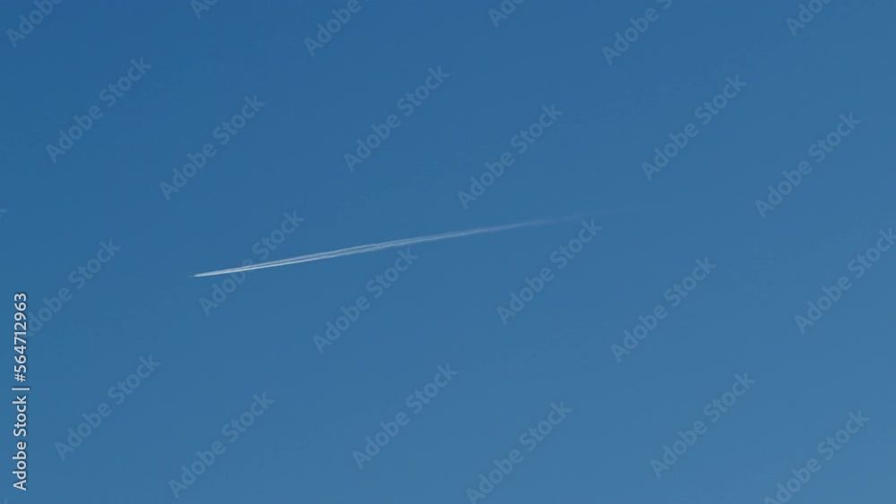 Airplane travel in the blue sky with trails behind it Airplane travel in the blue sky with trails behind it