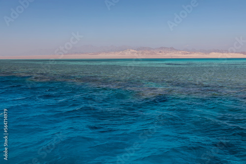 Beautiful blue sea. Colorful sea water. Sunny summer day. Shore in the distance.