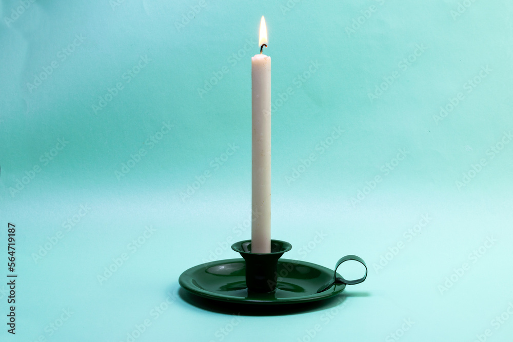 green candlestick with a burning candle