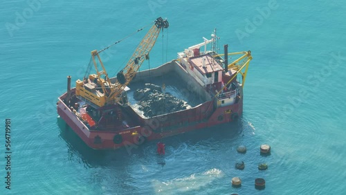 A boat is dredging the sea. Dredging is the removal of sediments and debris from the bottom of lakes, rivers, harbors, and other water bodies. 