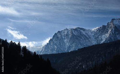 Caraiman Cross Monument (Crucea Eroilor Neamului in Romanian language) from Bucegi Mountains during a winter day with blue sky in Transylvania. Travel to Romania. photo