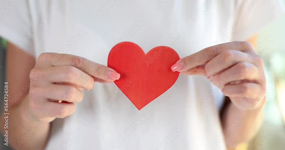 Female hands holding red paper heart closeup 4k movie slow motion Female hands holding red paper heart closeup 4k movie slow motion