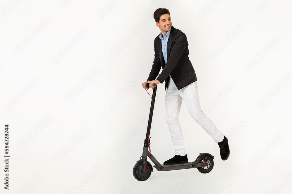 handsome man riding on electic kick scooter isolated on white studio background handsome man riding on electic kick scooter isolated on white studio background
