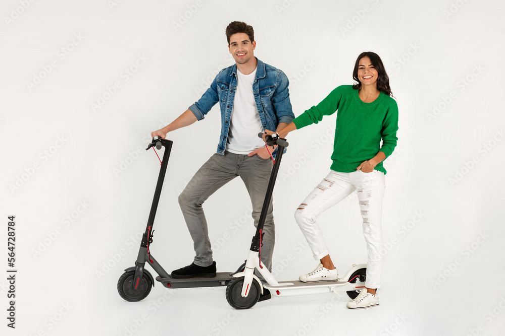 a couple riding on electic kick scooter isolated on white studio background a couple riding on electic kick scooter isolated on white studio background
