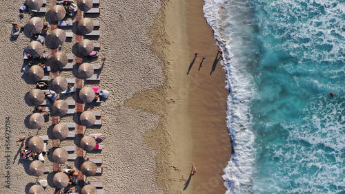 Aerial drone photo of famous for surfers organised with sun beds and umbrellas wavy beach of Armenistis in island of Ikaria, Aegean sea, Greece