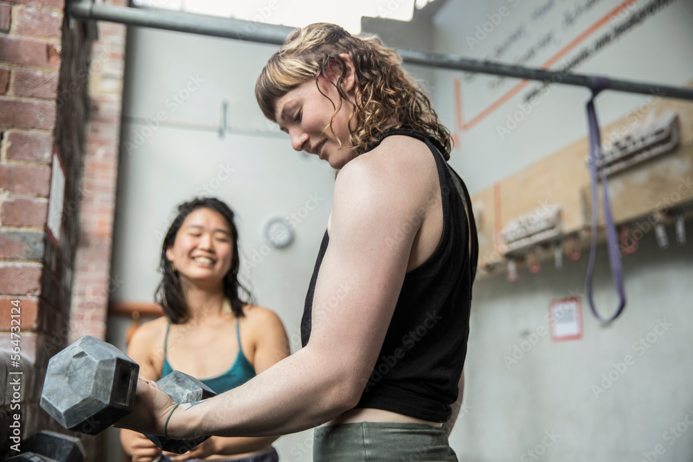 Young woman weight training with dumbbell in gym Young woman weight training with dumbbell in gym