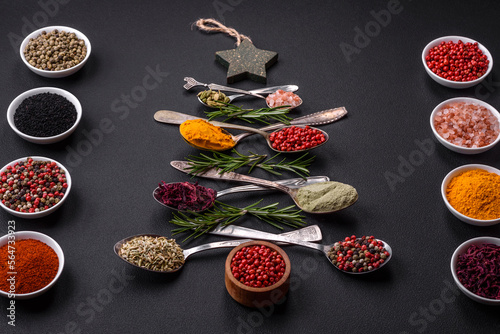 Composition consisting of a variation of spices in metal spoons laid out in the shape of a Christmas tree