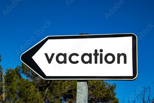 the word 'vacation' written on a road sign
